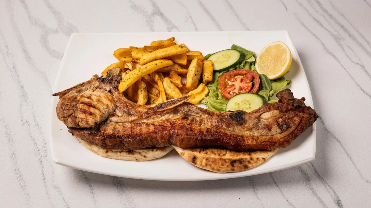 Grilled pork chop with fries and salad